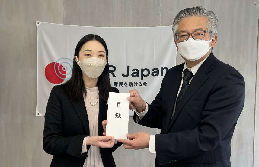 A donation list is handed over to Yuki Yoshizawa, acting secretary general (left in the photo), by a representative of Shinnyo-en.